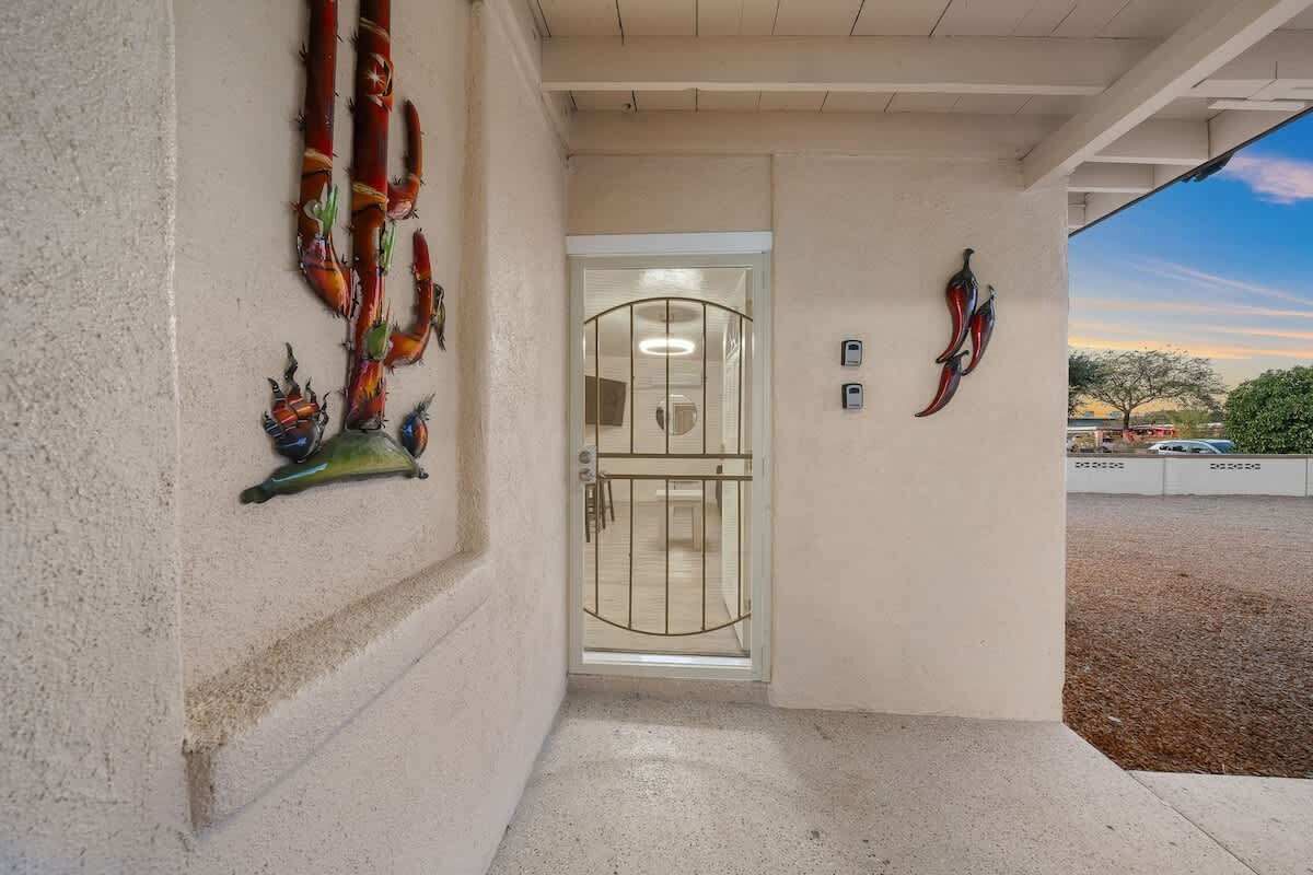 A building entrance with a glass door, decorative wall art, and a clear view of the surrounding area.