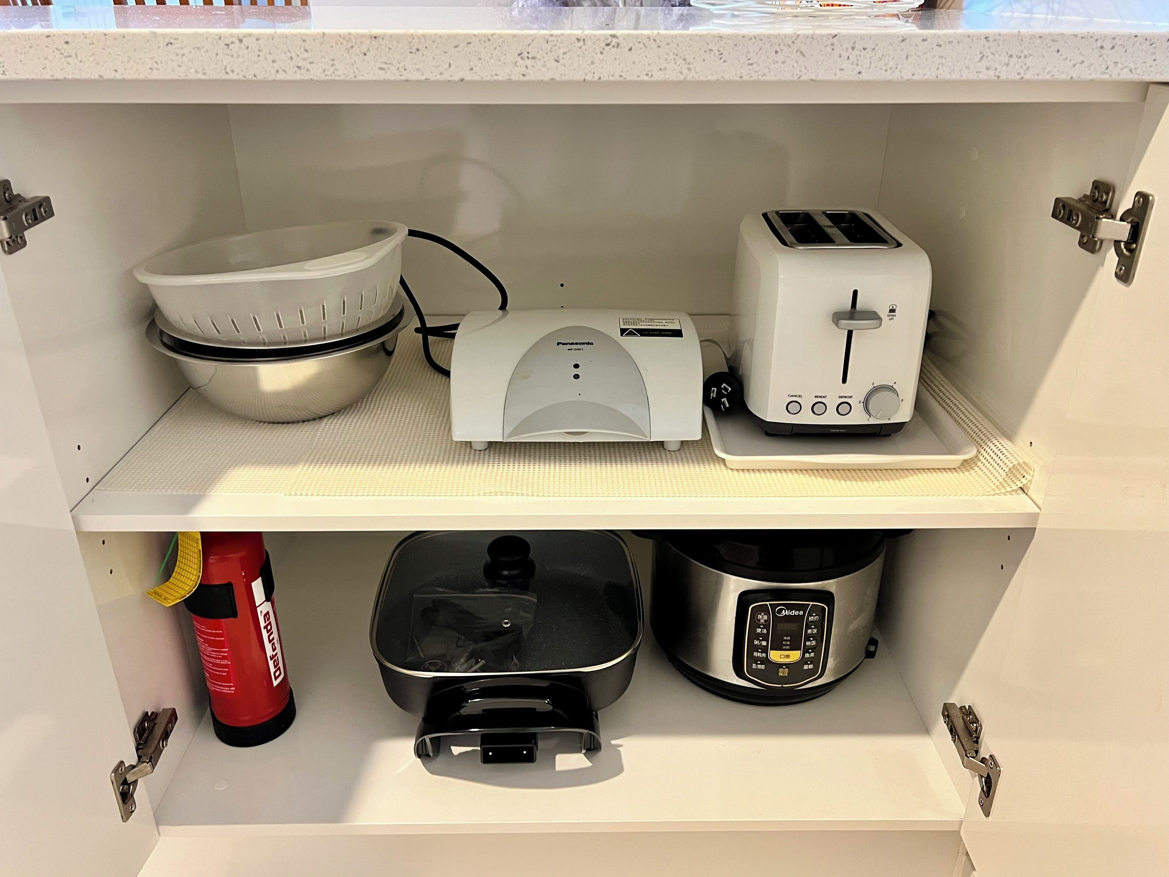 A kitchen with a mixer, toaster, and rice cooker on the countertop.