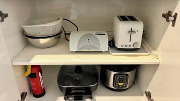 A kitchen with a mixer, toaster, and rice cooker on the countertop.