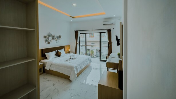 Een moderne hotelkamer met een bed, bureau en balkon.