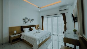 Een moderne hotelkamer met een groot bed, nachtkastjes, een bureau en een televisie.