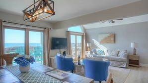 A spacious living room with a dining area, large windows, and a view of the ocean. - Oceanfront!  Newly renovated, 4 bd/3 bath, dog friendly, FAST-Wifi and Roku streaming! (North Topsail Beach)