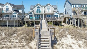 A beachfront property with multiple houses connected by a wooden walkway. - Oceanfront!  Newly renovated, 4 bd/3 bath, dog friendly, FAST-Wifi and Roku streaming! (North Topsail Beach)