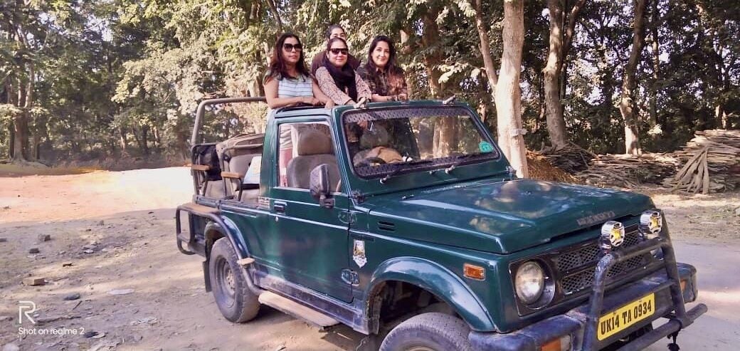 A green pickup truck with three passengers.