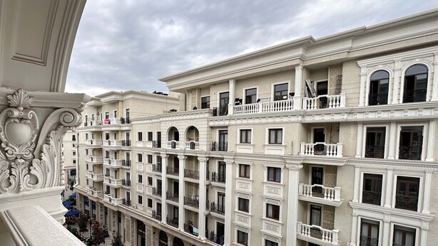 A multi-story building with ornate architectural details, balconies, and a uniform facade. - Boulevard 46 (Tashkent)
