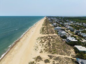An aerial view of a coastal residential area with houses, a beach, and a water body. - Rusty Dolphin is a well-maintained 2 level home with pool and hot tub. (Virginia Beach)
