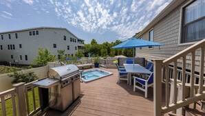 A deck with a hot tub, grill, and outdoor seating area. - Rusty Dolphin is a well-maintained 2 level home with pool and hot tub. (Virginia Beach)