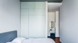 A modern bedroom with a bed, a wardrobe, a mirror, and a small desk. - Boulevard 115 (Tashkent)
