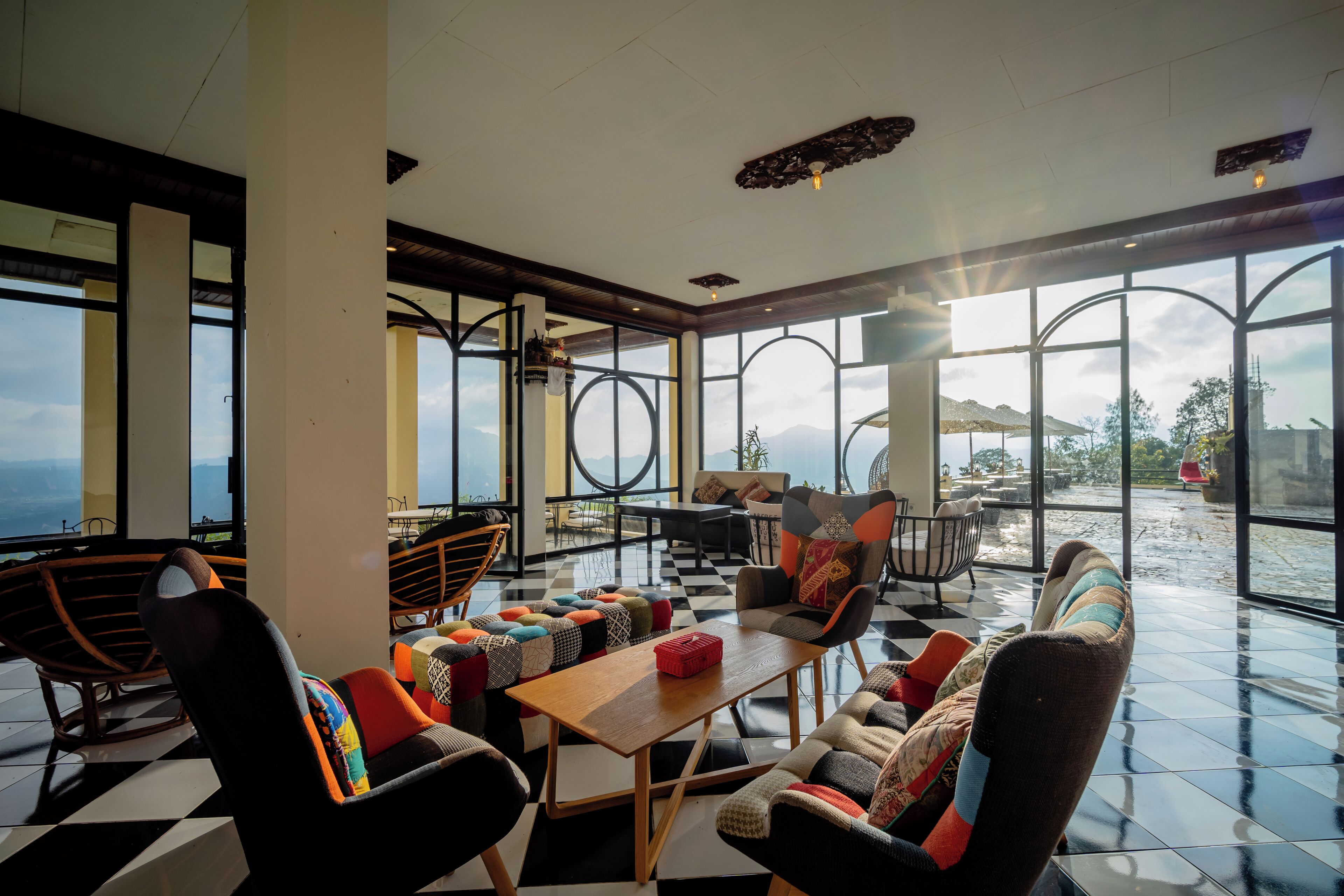 Un espacio interior amplio con ventanas grandes, suelo de cuadros y mobiliario moderno.