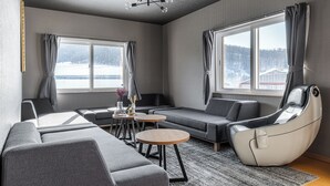 Un salon moderne avec un canapé, un fauteuil inclinable et une petite table.