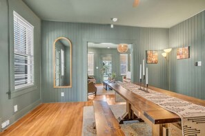Relax in a spacious room with a long bench, floor lamp, and framed artworks.