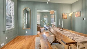 A spacious room with a long wooden table, a large mirror, and a bench.