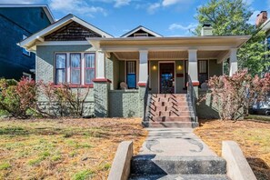Stunning two-story home with a central entrance, flanked by windows and a pitched roof.