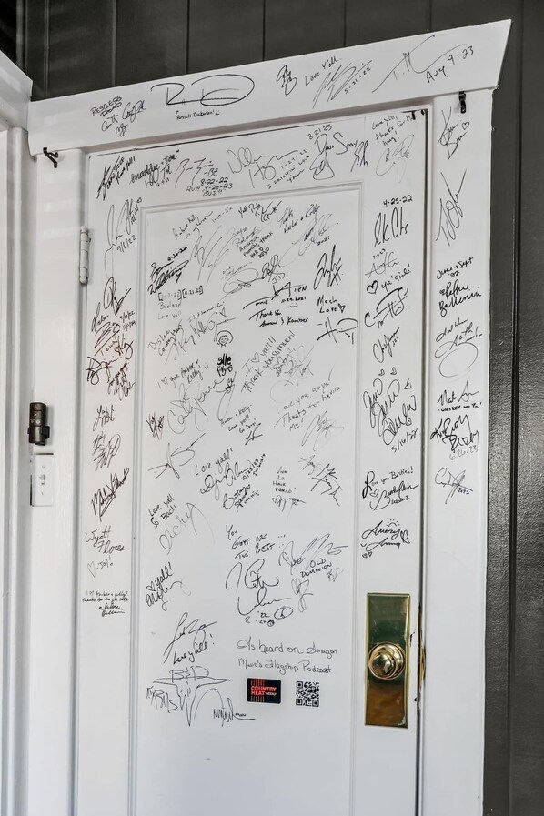 Una puerta blanca con numerosas firmas y mensajes escritos a mano.