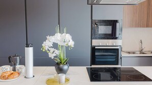 A modern kitchen with a built-in oven, a stovetop, and a coffee maker. - A bright and cozy Mellieha apartment with modern comforts, close to the beach, shops, and transport—perfect for a relaxing family or couple’s getaway. (Il-Mellieħa)