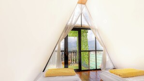 Ein gemütliches Zimmer mit Bett, Fenster und Bergblick.