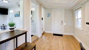 A hallway with wooden flooring, white walls, a door, and a potted plant. - 1 Mi to Lake Worth Beach Park: Chic Studio (Lake Worth Beach)