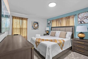A hotel room with a bed, bedside tables, a desk, and artwork on the walls. - Gorgeous 5bed TH close to Disney, Water Park (Davenport)