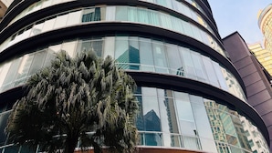 Un gratte-ciel moderne à la façade incurvée et doté de nombreuses fenêtres en verre.