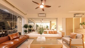 Un hall d’hôtel moderne avec des canapés en cuir, une table basse en bois et une grande plante décorative.
