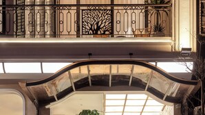 L’entrée d’un hôtel, avec une façade en pierre, une enseigne et un escalier menant à l’étage supérieur.