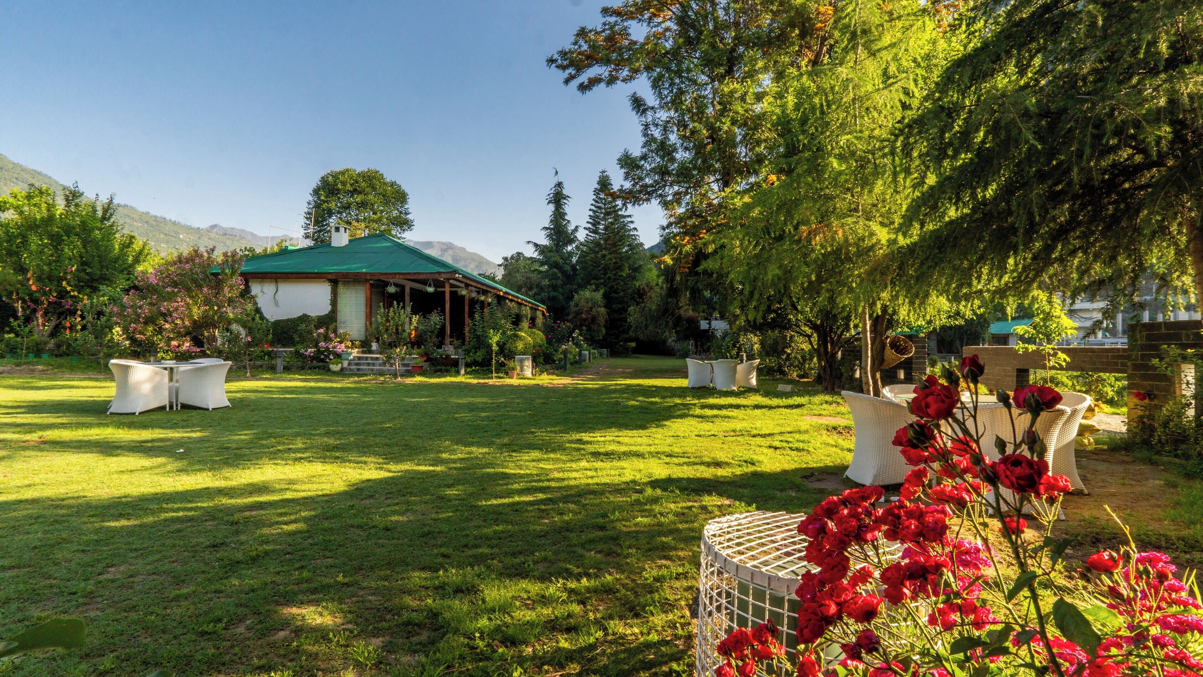 A garden with a gazebo, outdoor seating, and a variety of plants.