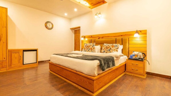 A bedroom with a wooden bed, a nightstand, a radiator, and a wooden wardrobe.