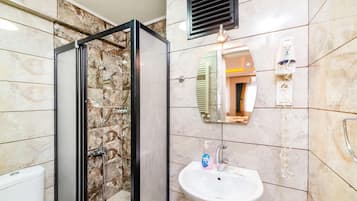 Familie studio | Badkamer | Een douche, een haardroger, pantoffels, handdoeken