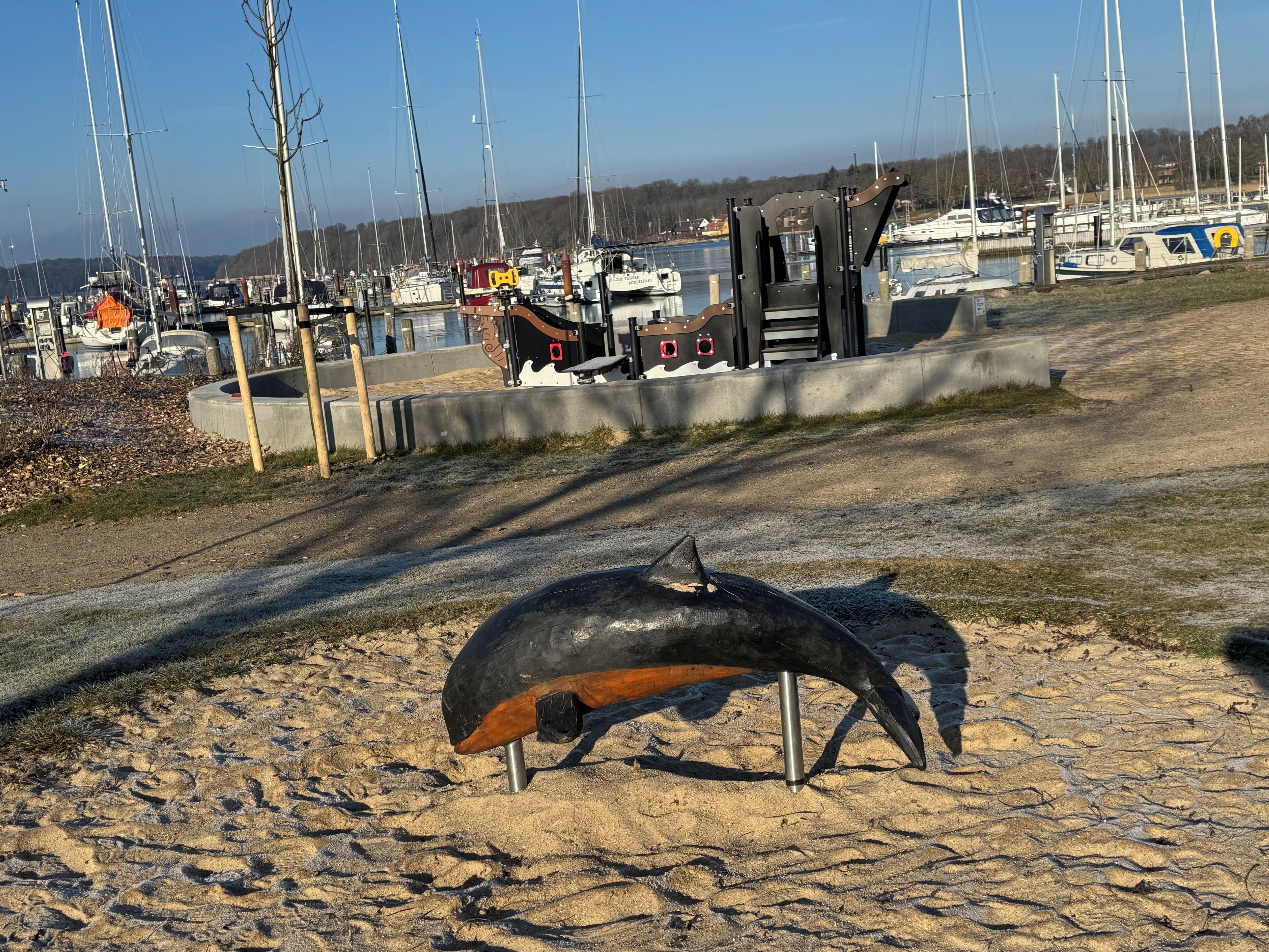 A sandy beach with a sculpture of a bird.