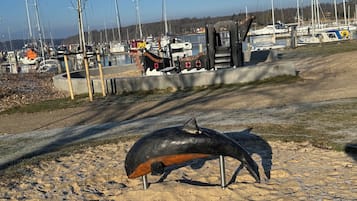 Une plage de sable ornée d’une sculpture d’oiseau.