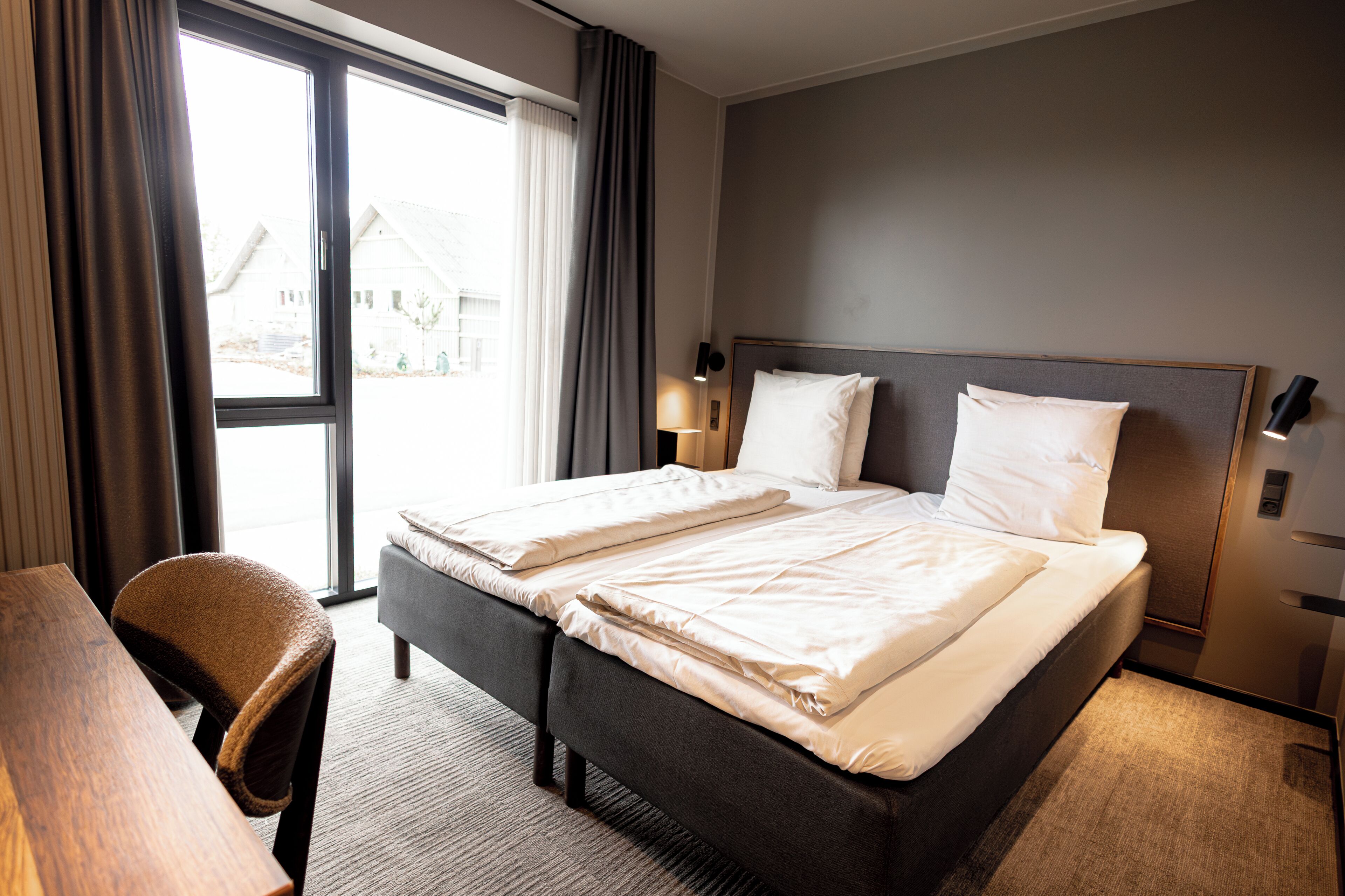Una habitación de hotel con una cama grande, un escritorio y una silla.