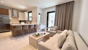 Un appartement moderne comprenant une cuisine, un coin repas et un salon.
