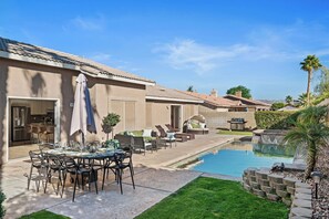 A residential property with a swimming pool, outdoor seating area, and a patio with a table set for dining. - La Quinta Desert Haven | Luxe Stay w/ Private Pool, Hot Tub, Pool Table (La Quinta)