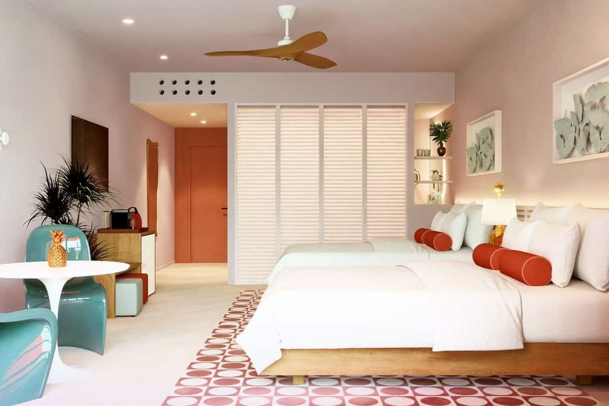 A modern bedroom with a bed, bedside tables, a desk, and a chair.