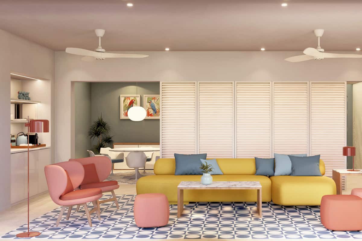 A modern living room with a yellow sofa, pink armchairs, and a coffee table. There are ceiling fans, a large mirror, and a patterned floor.