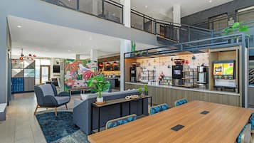 Ein modernes Interieur mit Essbereich, Küche und einer Treppe, die zwei Etagen verbindet.