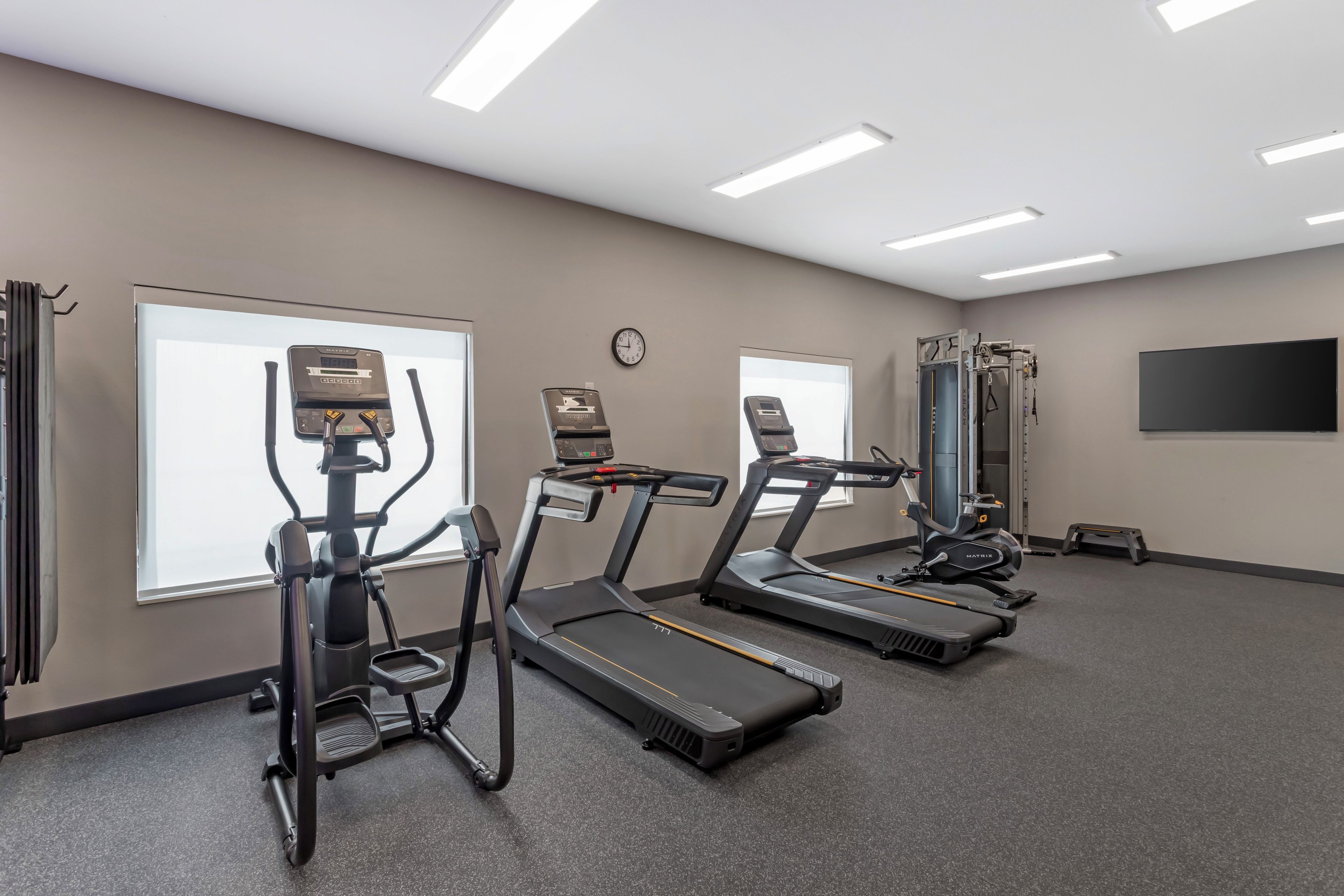 A fitness room with treadmills, a stationary bike, and a rowing machine.
