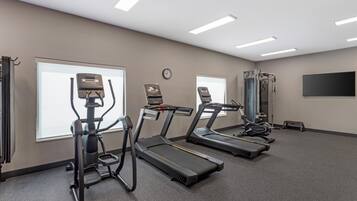 A fitness room with treadmills, a stationary bike, and a rowing machine.