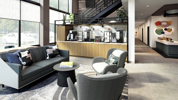 Un moderno vestíbulo de hotel con sofá, sillas, una barra de café y una escalera.