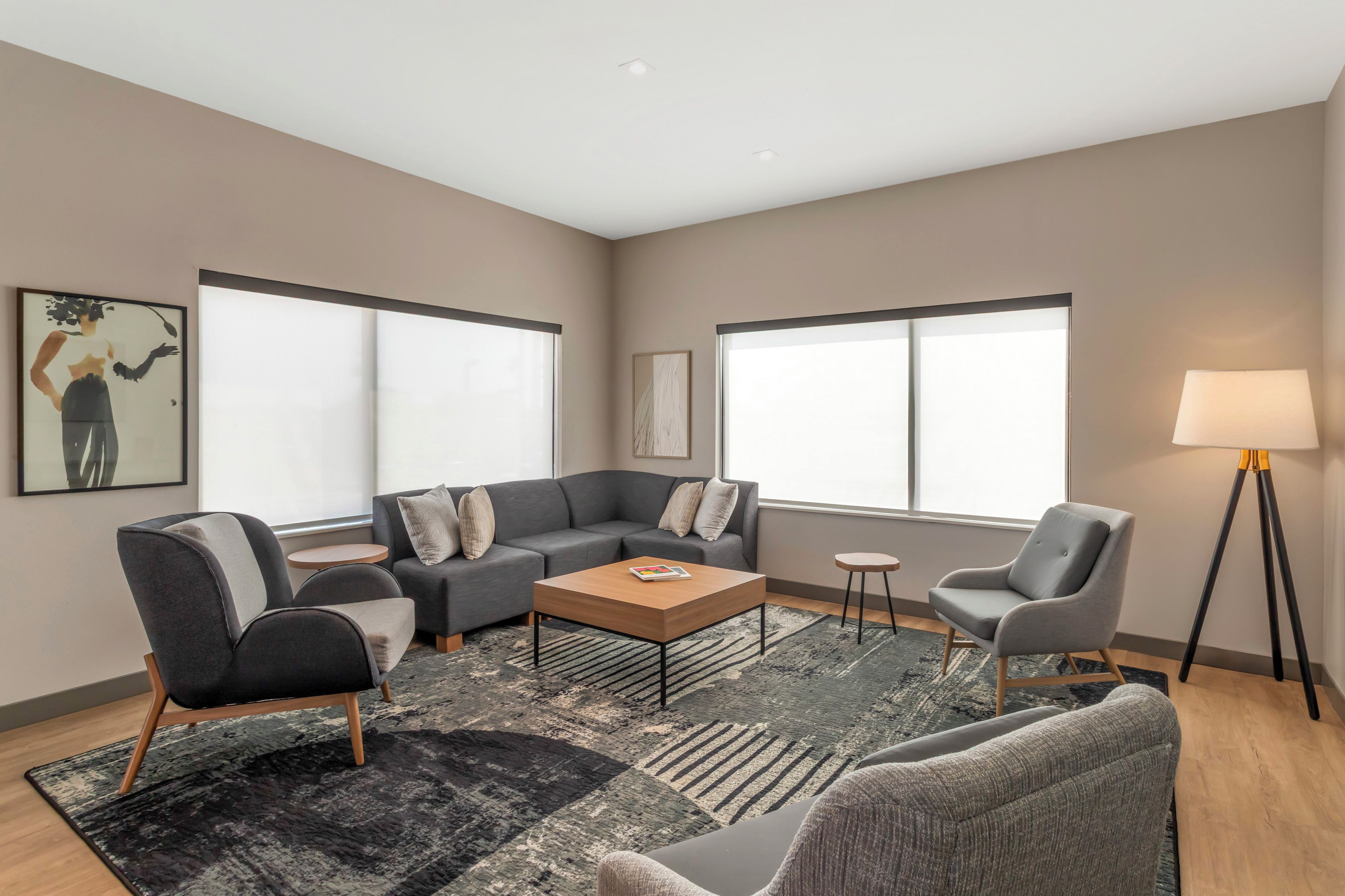 A modern living room with a sectional sofa, armchairs, a coffee table, and a floor lamp.