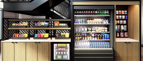 A modern retail space with a refrigerated display case and shelves stocked with snacks and beverages.