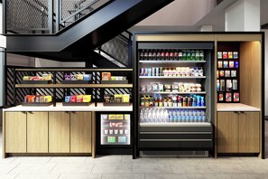 Un espace de vente moderne doté d’une vitrine réfrigérée et d’étagères remplies de collations et de boissons.