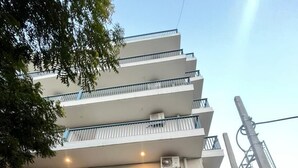 Un edificio residencial de varios pisos con balcones, una entrada principal y una escalera visible.