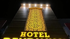 Ein Hotelschild mit beleuchteten Buchstaben, die 'HOTEL DEVBHUMI' anzeigen, vor dunklem Hintergrund.