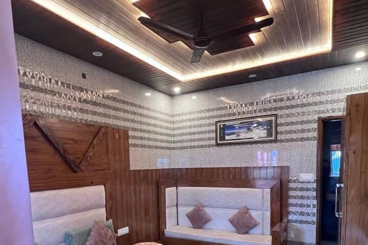 A bedroom with a bed, wooden headboard, and a ceiling fan.