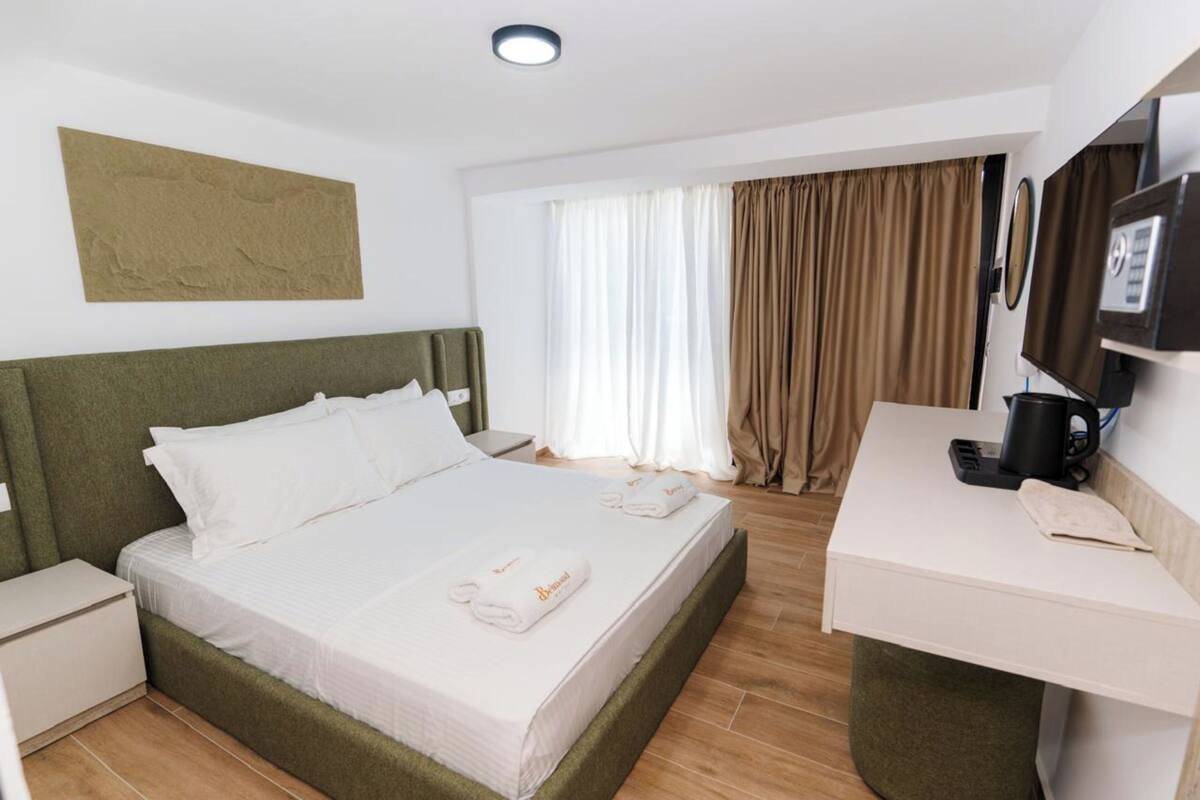 Una habitación de hotel con cama, escritorio, cafetera y televisor.