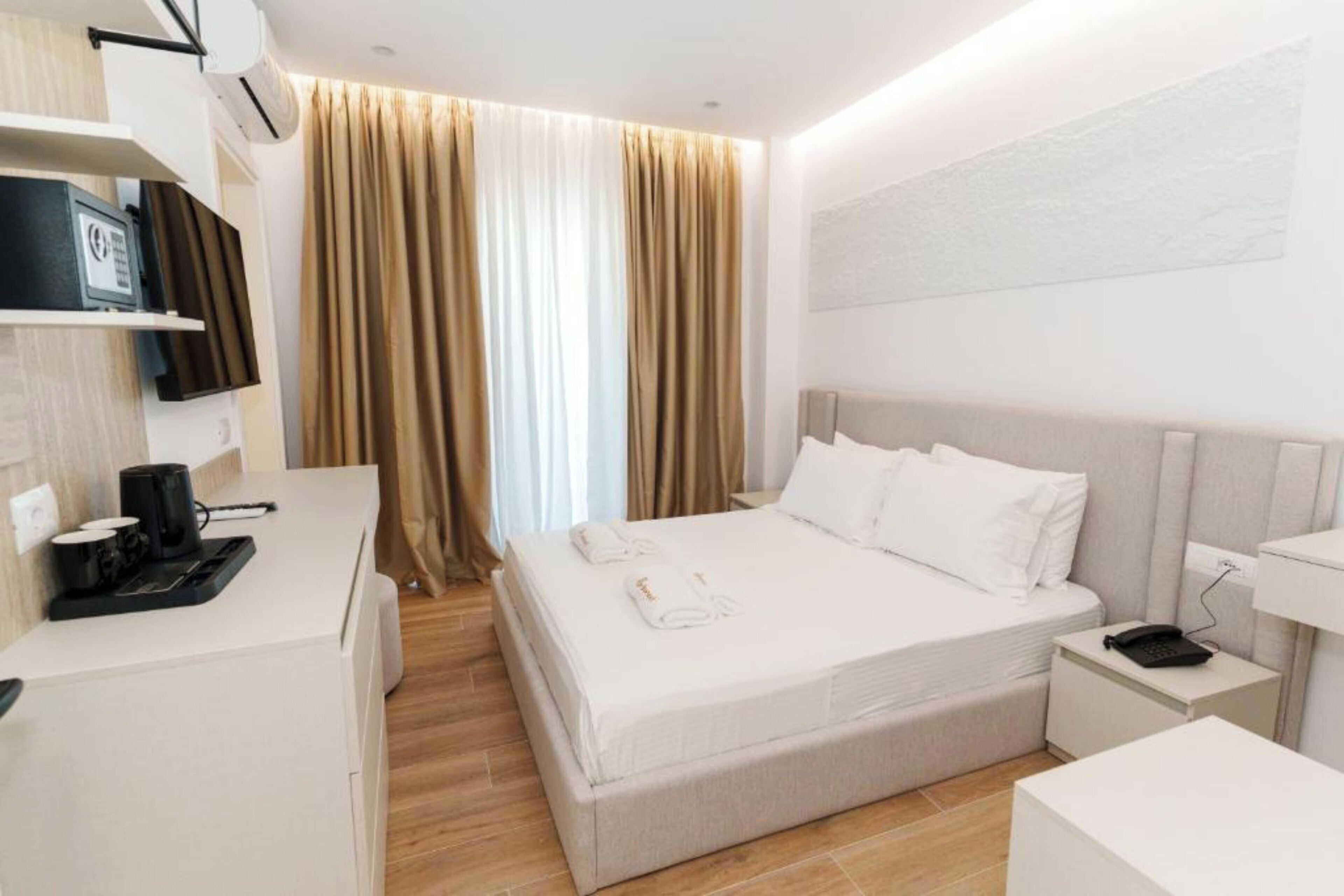 Una habitación de hotel moderna con una cama, una mesita de noche y un escritorio con cafetera.
