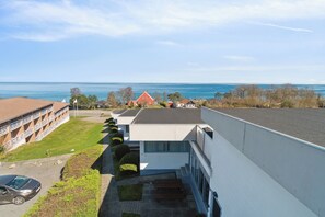 A modern building with a flat roof, a parking area, and a view of the sea. - Lovely summer house in Allinge-Sandvig (Allinge-Sandvig)