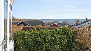 A residential area with houses, a hedge, and a view of the sea. - Lovely summer house with sea view (Sjølund)