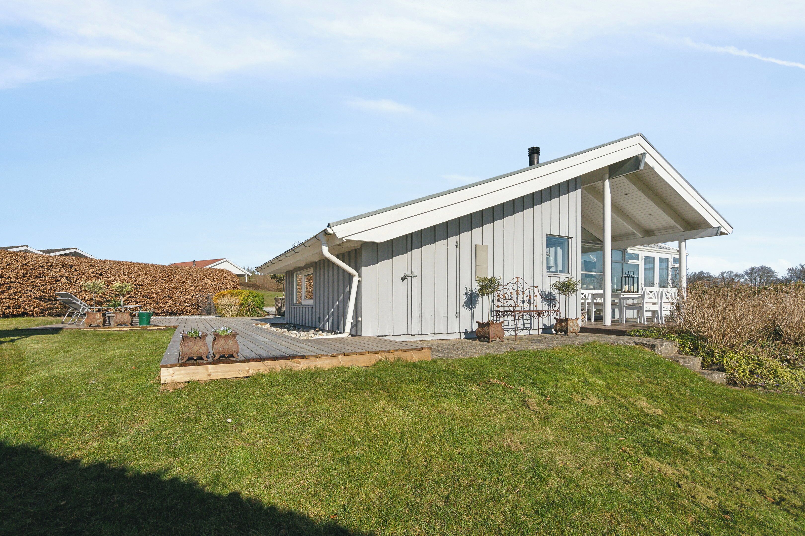 A modern house with a covered porch, a small shed, and a well-maintained lawn.